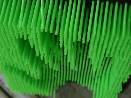Green plastic drinking straws in a factory, closeup of photoの写真素材