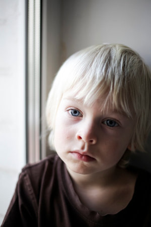 Portrait of a little boy with blond hair and blue eyes.の写真素材