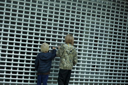 Children looking at the wall of the building.の写真素材