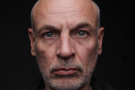 Portrait of a senior man on a black background. Studio shot.