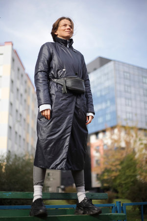 Outdoor fashion portrait of young beautiful woman wearing coat posing on the street.の写真素材