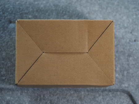 Brown cardboard box on grey background. Top view. Copy space.の写真素材
