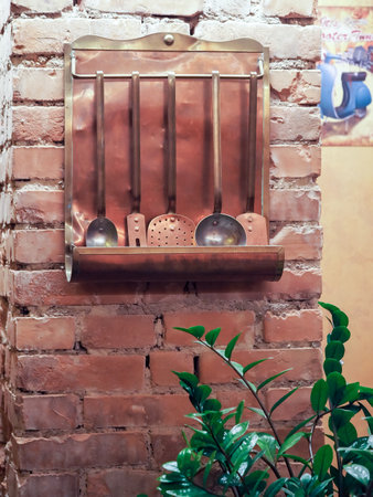 Brick wall with a metal holder for kitchen utensils.の写真素材