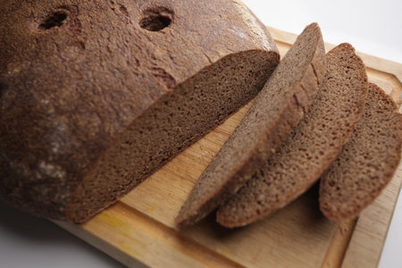 Brown bread on wooden cutting board. Shallow depth of field.