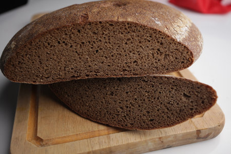 Sliced rye bread on cutting board on a white background.
