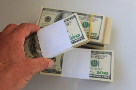 Dollars in the hand of a man on a white background