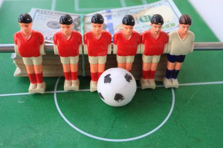 Table football players and soccer ball on the green field, sport background