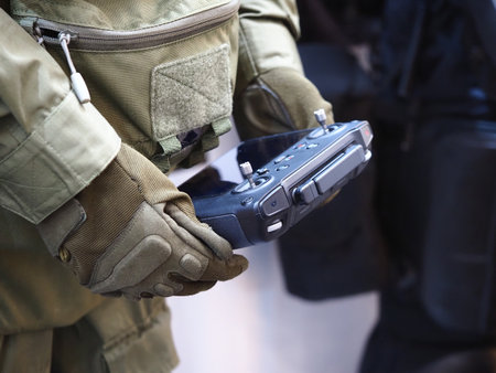 Close up of a soldier's hand holding a gun in a military uniformの写真素材