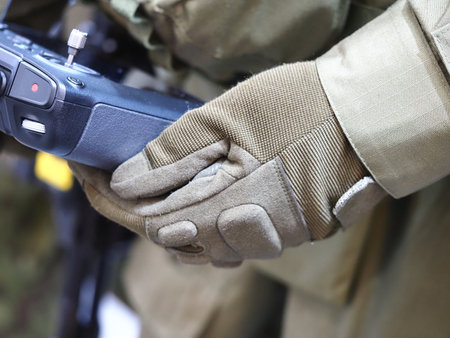 Soldier's hands in military gloves with a machine gun closeupの写真素材