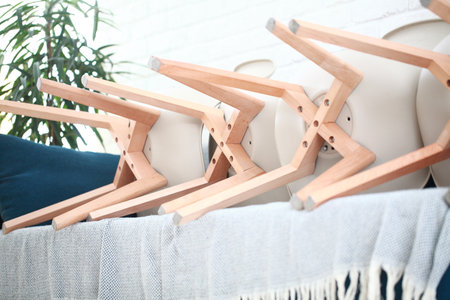 Wooden hangers on table in room, closeup. Interior design