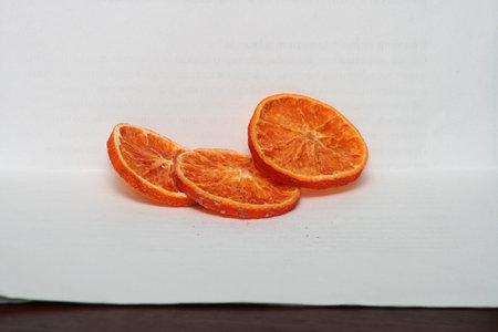 Slices of mandarin on a white sheet of paper.の写真素材