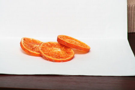 Slices of tangerine on a white sheet of paperの写真素材