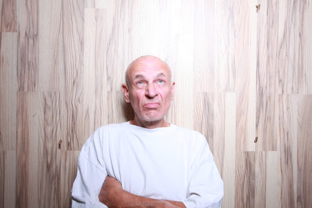 portrait of a bald man in a white T-shirt on a wooden backgroundの写真素材
