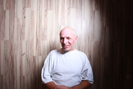 Portrait of a bald man in a white t-shirt on a wooden backgroundの写真素材
