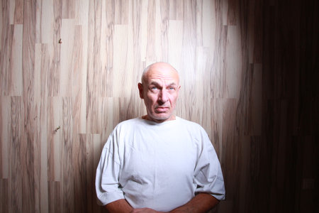 portrait of a bald man in a white T-shirt on a wooden backgroundの写真素材