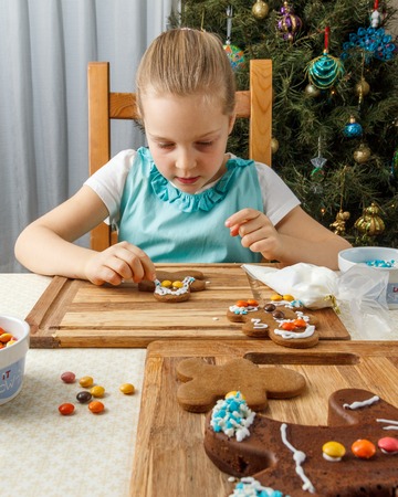 Little girl decorating of christmas gingerbread cookieの写真素材