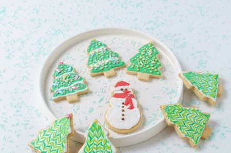 Festive Christmas snowman Cookie with decorated trees on white background