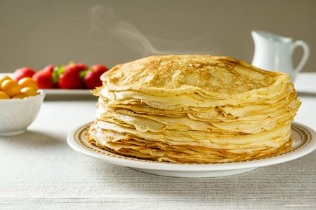 Pile of just made hot Russian pancakes or blini with berriesの写真素材