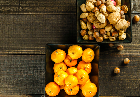 food background with mandarins and nuts on rustic tableの写真素材