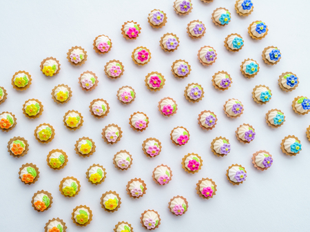 A lot of artificial cupcakes on white surface with shallow depth of field backgroundの写真素材