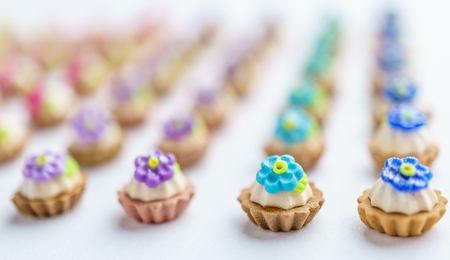 A lot of artificial cupcakes on white surface with shallow depth of field backgroundの写真素材