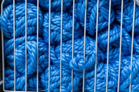 Balls of blue knitting yarn in white metal grid