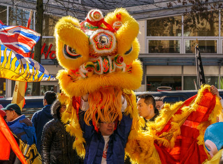 VANCOUVER, CANADA - February 18, 2014: People in Yellow Lion Costume at Chinese New Year parade in Vancouver Chinatown.のeditorial素材