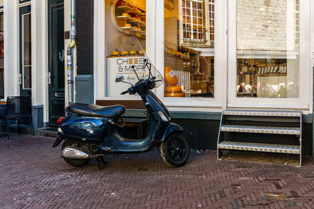 AMSTERDAM, NETHERLANDS - March 20, 2018 : Motorbike in front of the Cheese and more store in Amsterdamのeditorial素材