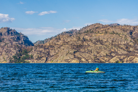 Okanagan Valley, Canada - August 05, 2018: Person is kayaking on an inflatable kayak in Okanagan lake BC Canadaのeditorial素材