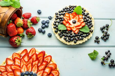 Cake with berries Pie with strawberries and black currants on blue rustic tableの写真素材