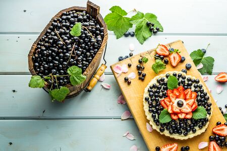 Cake with berries Pie with strawberries and black currants on blue rustic tableの写真素材