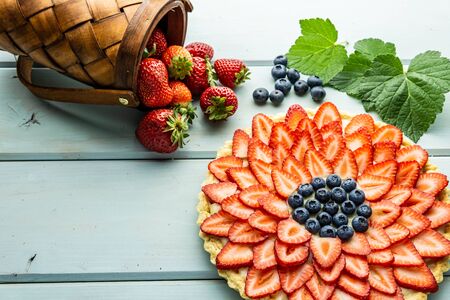 Cake with berries Pie with strawberries and blueberries on blue rustic tableの写真素材