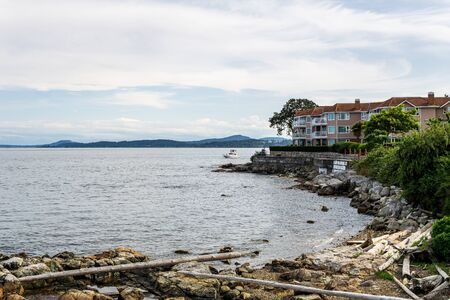 haro strait shore with residential building calm water and cloudy skyの写真素材