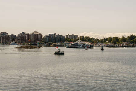 VICTORIA, CANADA - JULY 14, 2019: green sea bus in busy harbor at downtown area with yachts and...