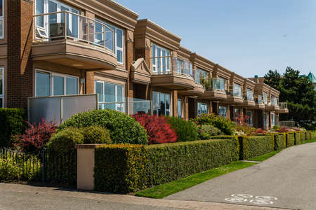 VICTORIA, CANADA - JULY 14, 2019: pathway in front of residential condo building on sunny day with...