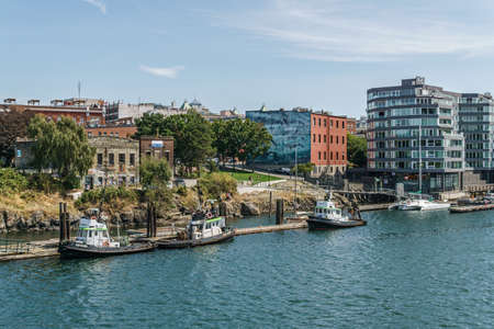 VICTORIA, CANADA - JULY 14, 2019: busy harbor at downtown area with yachts and modern buildingsのeditorial素材