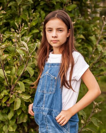 Cute little girls portrait in apple orchard.の写真素材