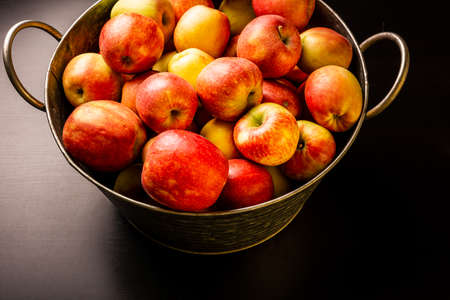 Ripe red apples in washtub on dark background top viewの写真素材