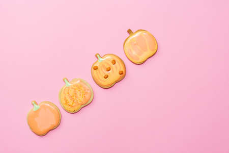Sweet homemade pumpkin cookie with icing isolated on pink background minimal flat lay composition.の写真素材