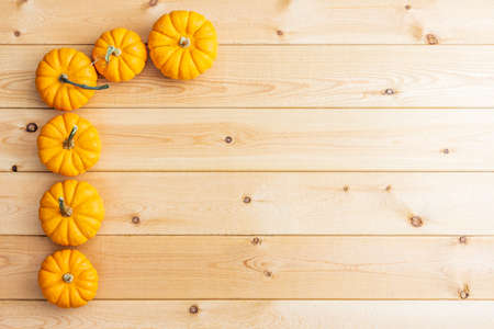 group of orange pumpkins on the wooden background top view.の写真素材