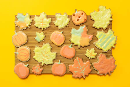 Sweet homemade cookie with icing on wooden board with yellow background flat lay composition.の写真素材