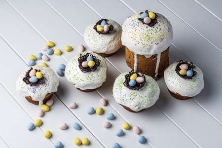 several traditional Easter cakes and candy eggs on white background decorated homemade pastry top...