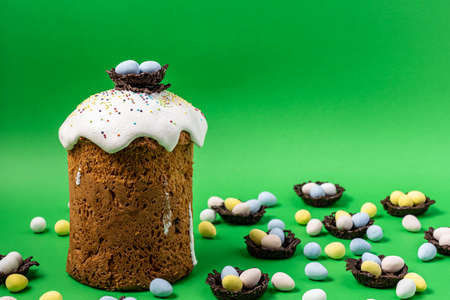 Easter Cakes or Paska and eggs composition on green background.