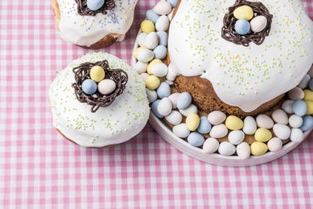 several traditional Easter cakes or sweet bread and candy eggs decorated homemade pastry top view.