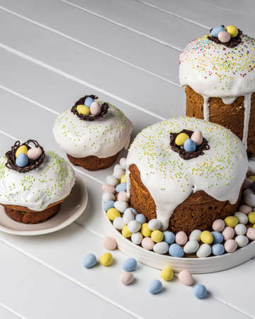 several traditional Easter cakes and candy eggs on white background decorated homemade pastry top view.の写真素材
