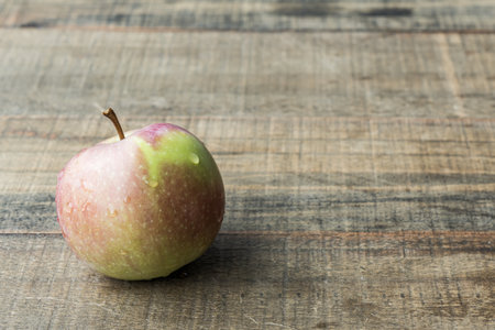 One fresh apple on a wooden tabletop fruit diet.の写真素材