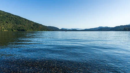 Panorama view Cultus lake against the beautiful big mountain covered with coniferous forest summer landscape.の写真素材
