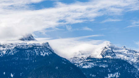 huge mountains covered by snow and sunny sky with clouds british columbia canada.の写真素材