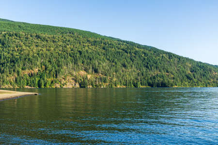 Cultus lake against the beautiful big mountain covered with coniferous forest summer landscape.の写真素材