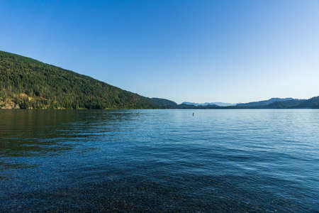 Cultus lake against the beautiful big mountain covered with coniferous forest summer landscape.の写真素材